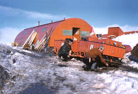 Denis St Onge and Richard Moskal cleaning mud from tracks of our snow mobile. Most frustrating. Q...